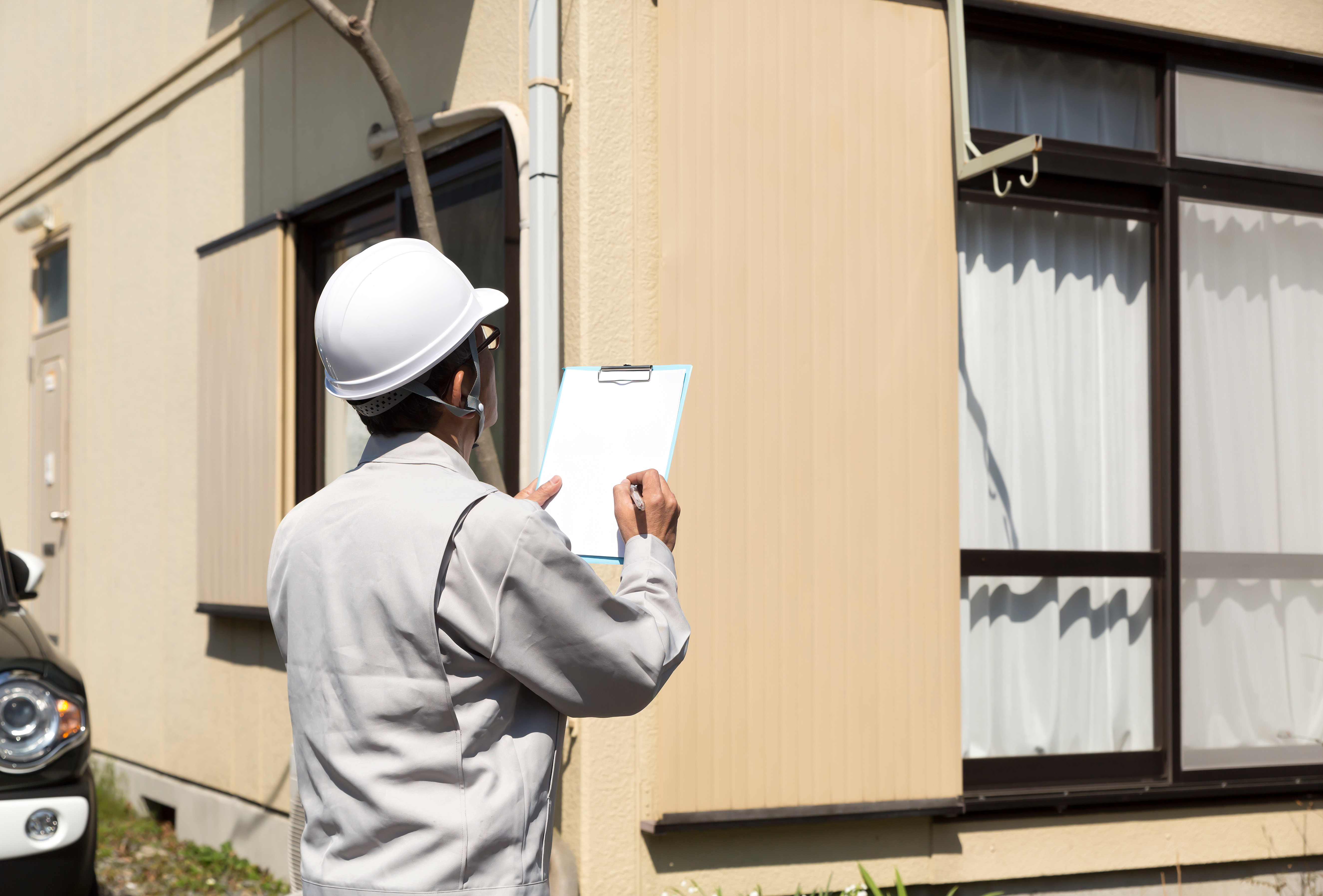 住宅とヘルメットの男性・現地調査